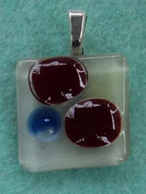 Pendentif petit et carré, arrière blanc, avec deux fragments rouge et un éclat bleu