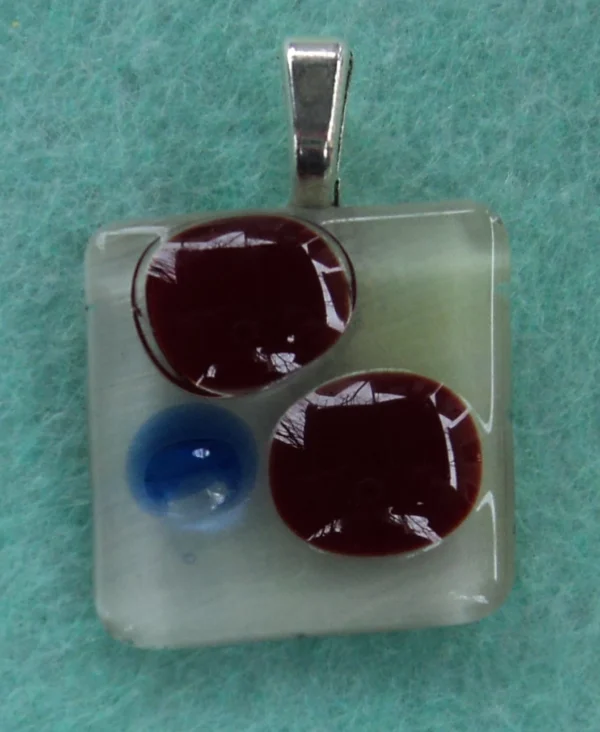 Pendentif petit et carré, arrière blanc, avec deux fragments rouge et un éclat bleu