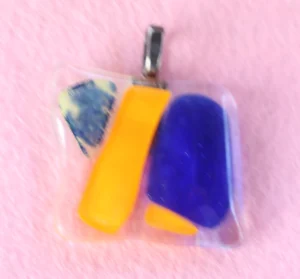 Pendentif carré en verre transparent recouvert d'éclats orange, bleu et multicolore