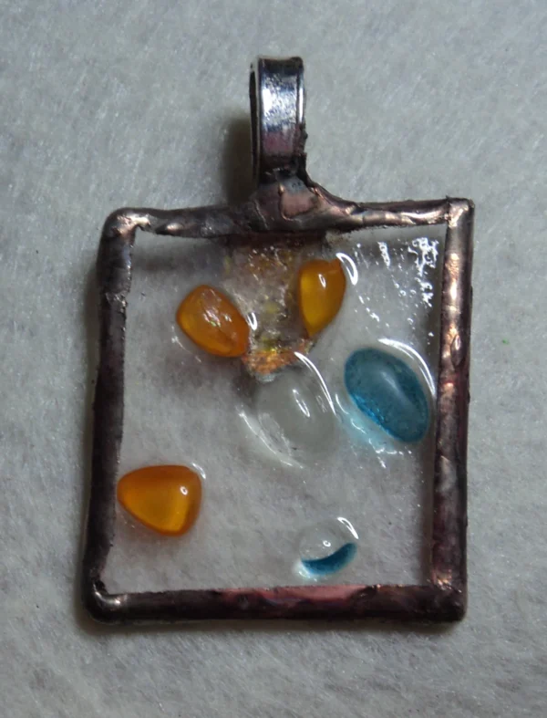 Pendentif en verre transparent avec des éclats multicolores fondus. Monté selon la technique de Tiffany (bords meulés, serti au cuivre, soudé à l'étain et patiné).