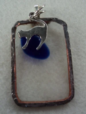 Pendentif en verre transparent avec un éclat bleu fondu. Monté en Tiffany. Une breloque en forme de chat.