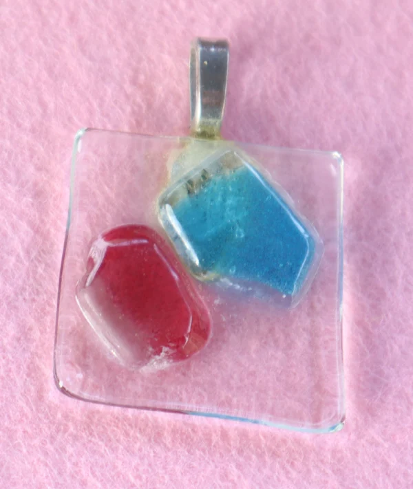 Pendentif carré en verre transparent avec un éclat bleu et un rouge fondus