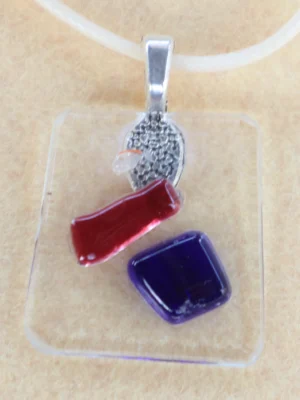 Pendentif en verre transparent avec des éclats bleu, rouge et blanc fondus