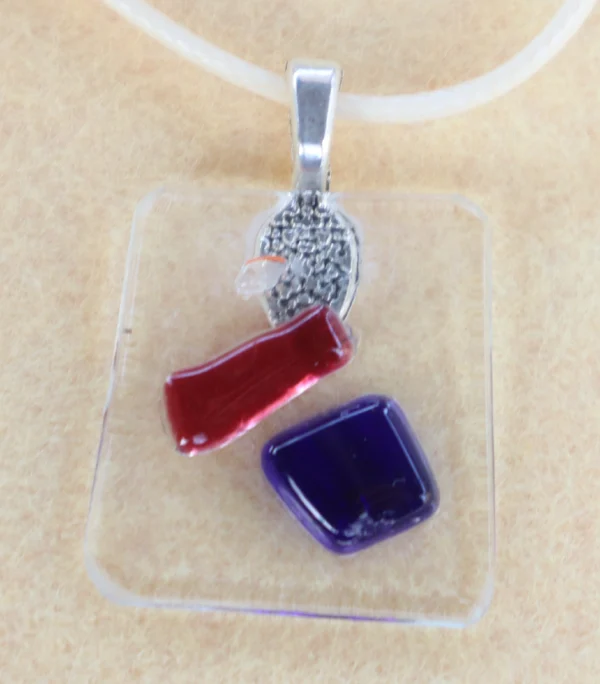 Pendentif en verre transparent avec des éclats bleu, rouge et blanc fondus