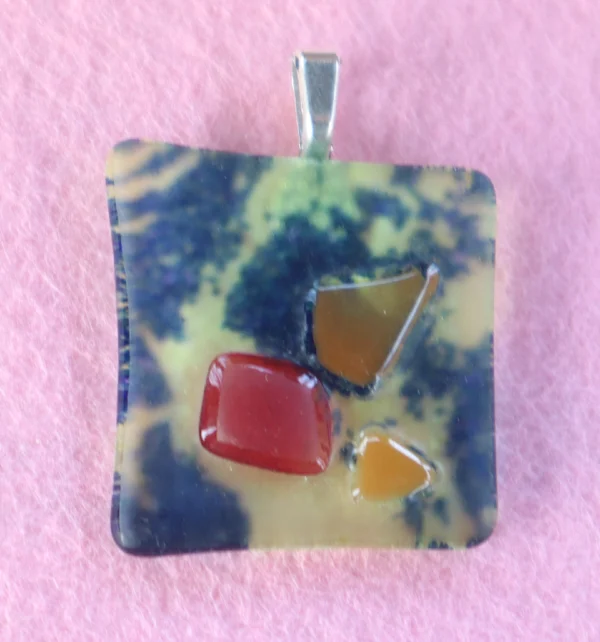 Pendentif carré fond bleu parsemé de jaune avec 3 éclats fondus rouge et orange