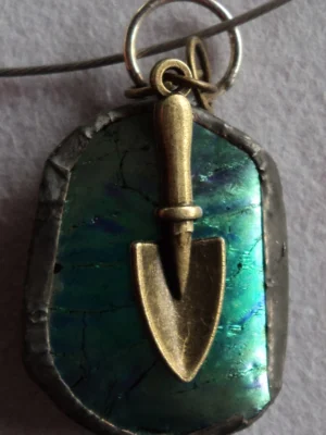 Pendentif en verre dichroïque vert, avec une breloque dorée en forme de truelle, monté en Tiffany