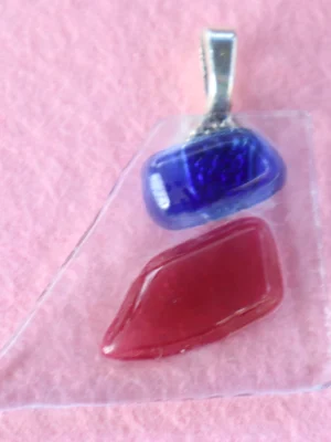 Pendentif en forme de triangle au sommet tronqué en verre transparent avec un éclat bleu et un rouge fondus