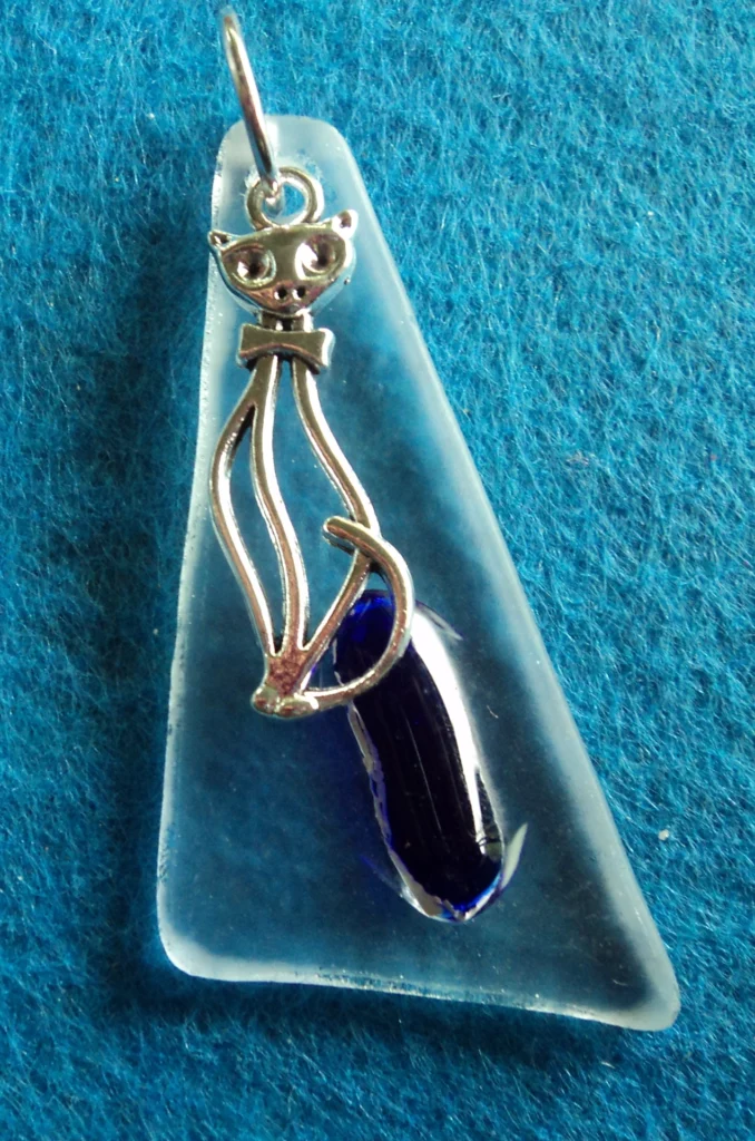 Pendentif triangulaire en verre transparent, avec une larme bleue et une breloque en forme de chat stylisé