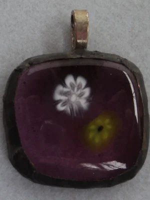 Pendentif mauve avec un millefiori blanc et un jaune, monté en Tiffany