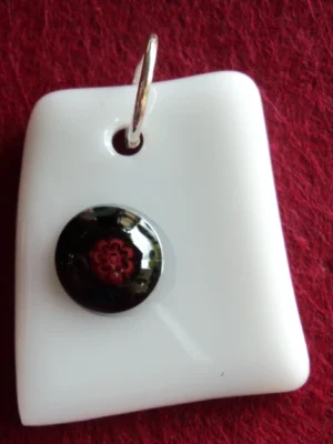 Pendentif en verre blanc avec un millefiori noir au cœur rouge