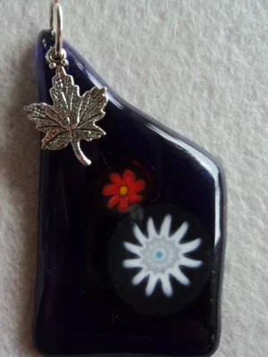 Pendentif en verre bleu nuit avec 1 millefiori blanc et 1 orange, une breloque en forme de feuille