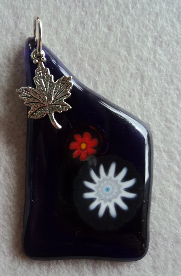 Pendentif en verre bleu nuit avec 1 millefiori blanc et 1 orange, une breloque en forme de feuille