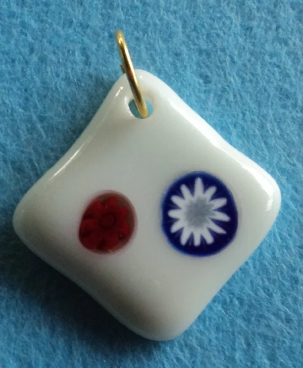 Pendentif en forme de losange en verre blanc avec deux millefioris, un rouge et un bleu et blanc