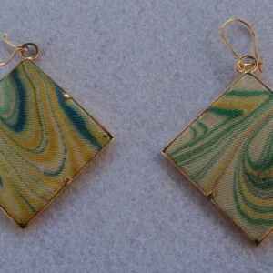 Boucles d'oreilles losange en soie marbrée avec un encadrement en métal doré. Une fixation permet de les fixer pour des oreilles percées.
