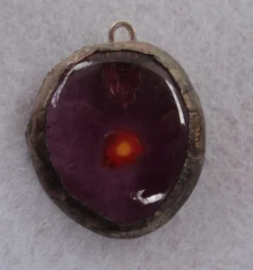 Pendentif ovale en verre mauve transparent avec un millefiori orange