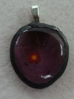 Pendentif ovale mauve avec un millefiori orange, monté en Tiffany