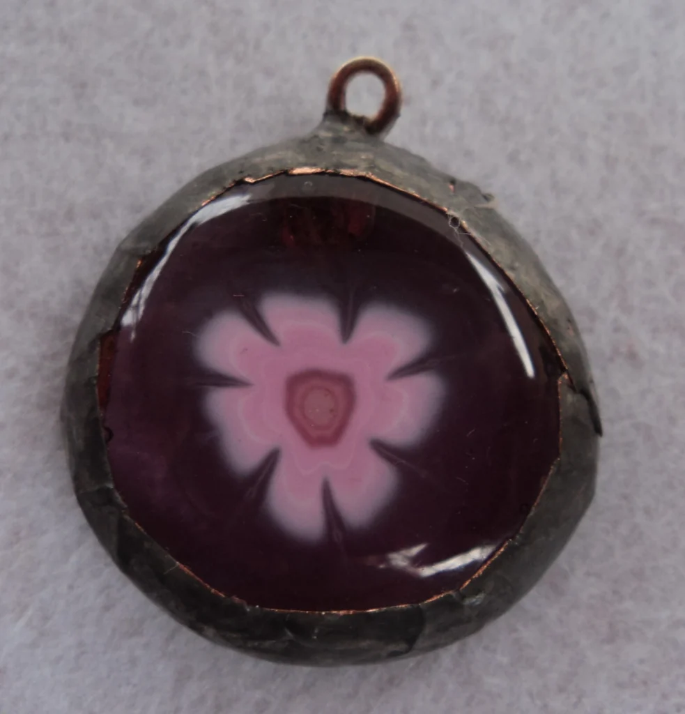 Pendentif circulaire mauve transparent avec un millefiori rose