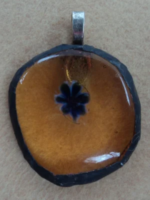 Pendentif millefiori bleu bordé de blanc sur fond orange transparent, monté en Tiffany