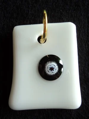 Pendentif en verre opaque blanc avec un millefiori noir au cœur blanc