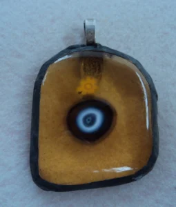 Pendentif millefioris jaune et millefiori bleu au coeur blanc, fondus sur verre orange transparent de forme ogivale