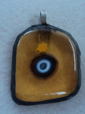 Pendentif millefioris jaune et millefiori bleu au coeur blanc, fondus sur verre orange transparent de forme ogivale