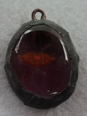 Pendentif ovale mauve avec un millefiori orange étalé