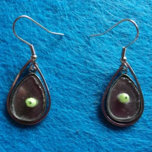 Des boucles d'oreilles composées de millefioris colorés, fondus sur du verre récupéré sur des sous-verres cassés. Monture en métal argenté inoxydable.