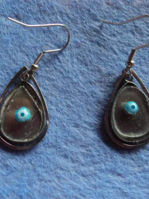 Des boucles d'oreilles composées de millefioris colorés, fondus sur du verre récupéré sur des sous-verres cassés. Monture en métal argenté inoxydable.