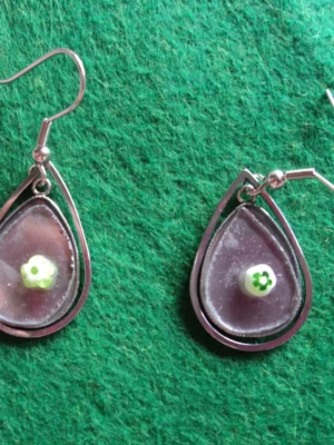 Des boucles d'oreilles composées de millefioris colorés, fondus sur du verre récupéré sur des sous-verres cassés. Monture en métal argenté inoxydable.