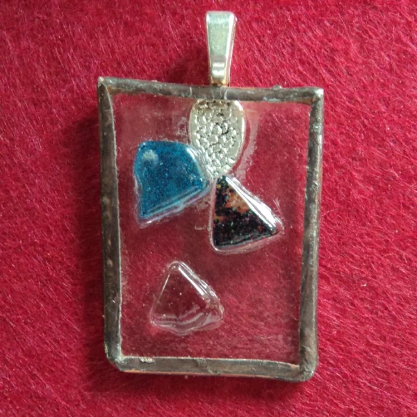 Rectangle en verre transparent avec des éclats bleus et rouge fondus. Monté en Tiffany.