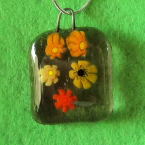 Pendentif en verre mauve semi transparent avec 5 millefioris jaune et orangé.