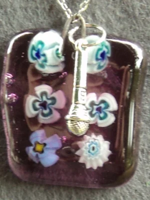 Pendentif en verre mauve semi-transparent avec 6 millefioris blanc et bleu et une breloque micro.