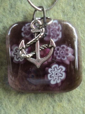 Pendentif en verre mauve semi-transparent avec 6 millefioris blanc et mauve et une breloque ancre de marine