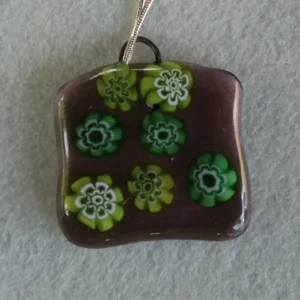 Pendentif en verre mauve semi transparent avec 7 millefioris vert.