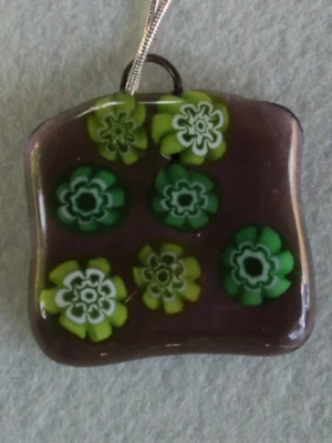 Pendentif en verre mauve semi transparent avec 7 millefioris vert.