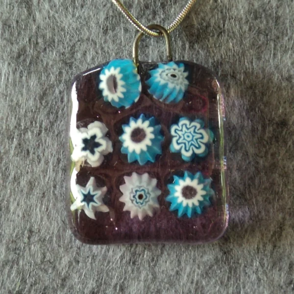 Pendentif en verre mauve semi transparent avec 8 millefioris bleu turquoise et blanc.