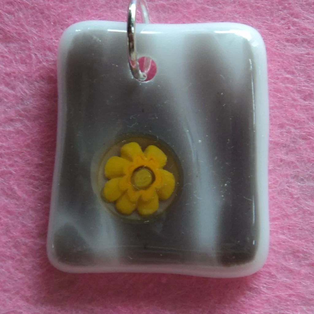 Pendentif rectangulaire gis et blanc avec un millefiori jaune