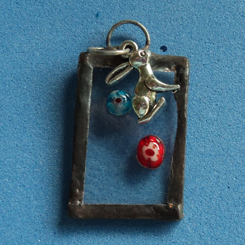 Pendentif rectangulaire avec millefioris et lapin assis. Monté en Tiffany.