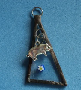 Pendentif triangulaire avec millefioris et cochon. Monté en Tiffany.