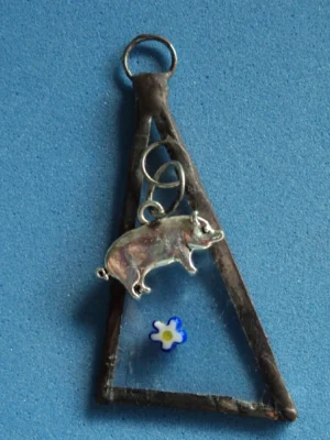 Pendentif triangulaire avec millefioris et cochon. Monté en Tiffany.