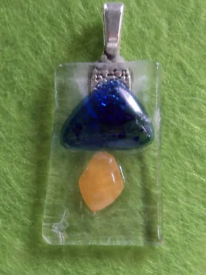 Pendentif rectangulaire en verre transparent avec des éclats bleu et orange.