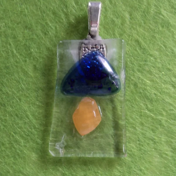 Pendentif rectangulaire en verre transparent avec des éclats bleu et orange.