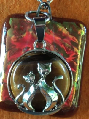 Pendentif rectangulaire en verre dichroïque doré / rose sur verre orange semi-transparent. Une breloque avec 2 chats amoureux sur œil de tigre