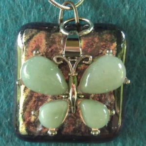 Pendentif carré en verre dichroïque argenté et rose, sur verre orange semi-transparent. Une breloque représentant un papillon en aventurine