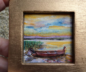 Barque amarrée au soleil couchant sur le lac. Mini tableau à la tempéra tenu dans la main