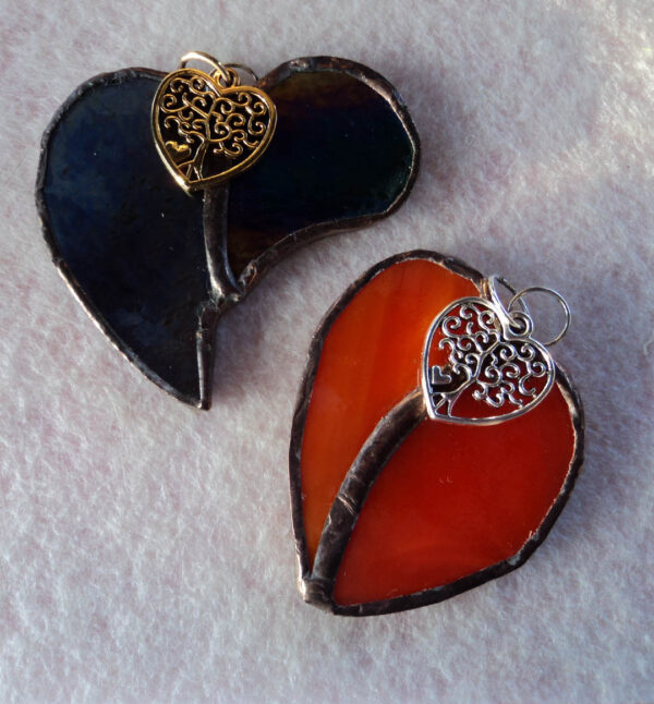 2 Pendentifs en forme de cœur, un gris foncé et un orange, en verre récupéré sur de grands vitraux. Des arbres de vie en métal ont été fixés