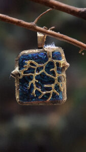 Pendentif en verre dichroïque fondu avec une branche dorée