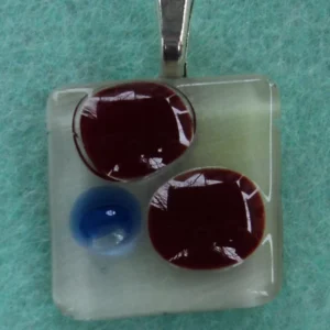 Pendentif fusing rouge et bleu sur fond blanc